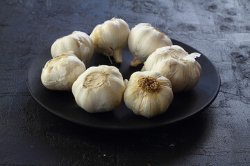 A garlic flatlay on black background. Top view. Copy space