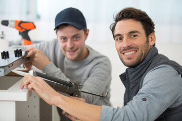 two men installing a kitchen hob