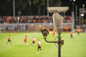 CCTV camera at football stadium with match in the background