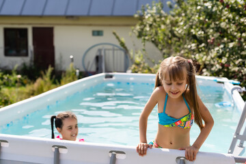 Kids in swimming pool. Girl swim outdoors.