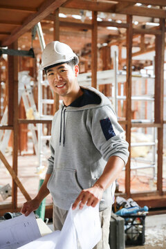 Builder checking construction plans on-site