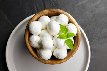 Mini mozzarella balls with basil in wooden plate