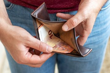 Poor man hand open wallet with one 10 euro banknote. Concept of financial crisis and poverty.