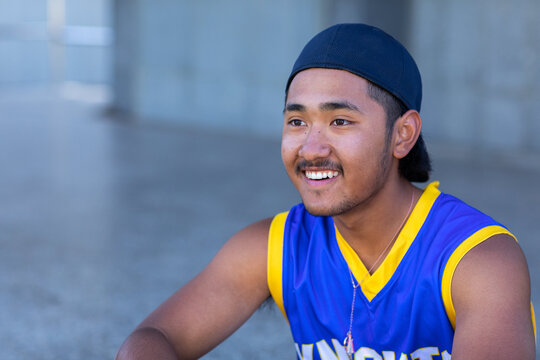 smiling youth wearing baseball shirt and cap on backwards