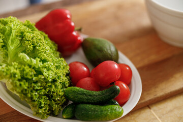 Beautiful smily handsome woman is preparing tasty fresh healthy salad at her kitchen at home