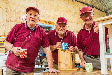 Three men sharing a cup of coffee at a Men's Shed
