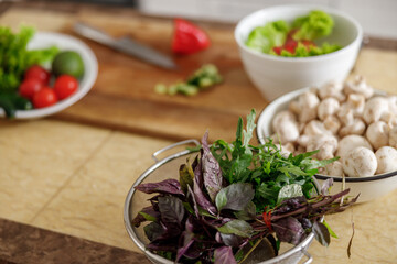 Beautiful smily handsome woman is preparing tasty fresh healthy salad at her kitchen at home