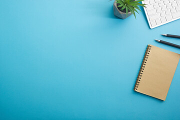 Blue desk office with laptop, smartphone and other work supplies with cup of coffee. Top view with copy space for input the text. Designer workspace on desk table essential elements on flat lay