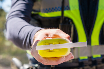 policeman holding an alcohol testing unit