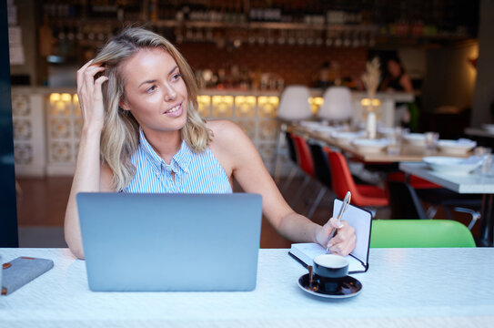 Young woman freelancing from her laptop at cafe