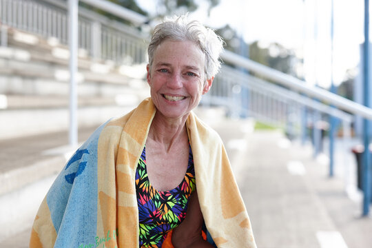Active senior lady with towel at swimming pool