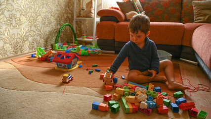 Child playing with toys while sitting on the carpet