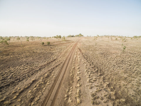 Drone shot of dirt road through a paddock