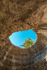 A hole from which the sun's rays and the sky are visible outside of an underground cave, an abnormal natural phenomenon in the rocks in the Crimea