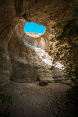 A hole from which the sun's rays and the sky are visible outside of an underground cave, an abnormal natural phenomenon in the rocks in the Crimea