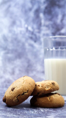 American gluten free chocolate chip cookies with glass glass of vegetable milk on gray background. Chocolate chip cookies. Sweet pastries, dessert. Culinary background. Vertical photography.