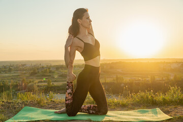 Young woman meditating in a yoga at nature at sunset.