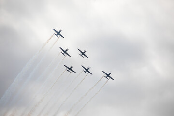Fighter jets in the sky in airshow against clouds and sky precision flying machines against the sky clouds riding together team work collaboration close 