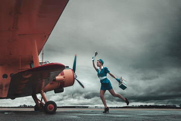 Vintage flight attendant running to catch up the plane before departure
