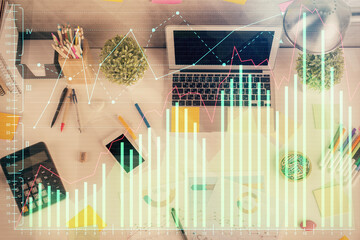 Double exposure of forex chart drawing over table background with computer. Concept of financial research and analysis. Top view.
