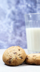 American gluten free chocolate chip cookies with glass glass of vegetable milk on gray background. Chocolate chip cookies. Sweet pastries, dessert. Culinary background. Vertical photography.