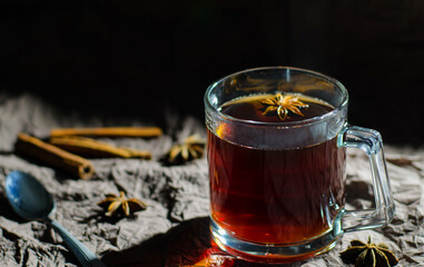 A glass of tea with spices served with cinnamon and badian