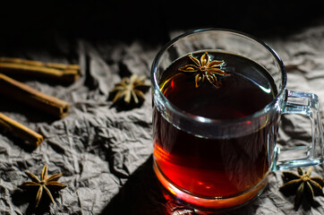 A glass of tea with spices served with cinnamon and badian