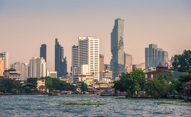Fototapeta na wymiar City Skyline as Seen from the Tourist Boat on Chao Phraya River at Sunset in Bangkok, Thailand