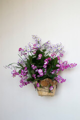 Artificial flowers on a light background. Flower basket