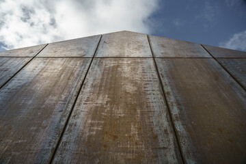 Corten steel cladding on end of house with blue sky and clouds