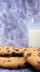 American gluten free chocolate chip cookies with glass glass of vegetable milk on gray background. Chocolate chip cookies. Sweet pastries, dessert. Culinary background. Vertical photography.