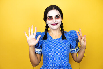 woman wearing a scary doll halloween costume over yellow background showing and pointing up with fingers number seven while smiling confident and happy