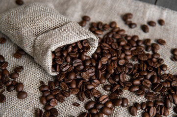 Coffee scattered from a linen bag. Fresh arabica coffee beans on linen textile.