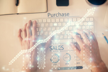 Double exposure of man's hands typing over laptop keyboard and forex chart hologram drawing. Top view. Financial markets concept.