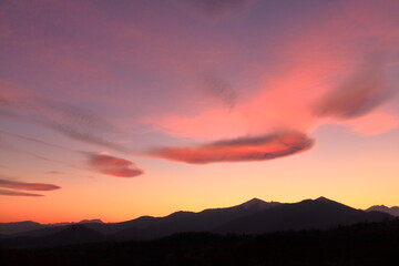 a romantic sunset with pink clouds over the Italian Alps