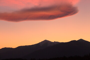 a romantic sunset with pink clouds over the Italian Alps