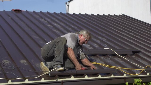 Worker roofer builder working on roof structure on construction site