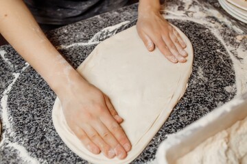 hands knead the dough for pizza making