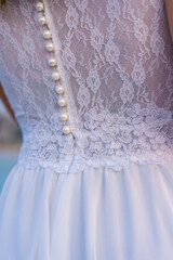 Fototapeta na wymiar Lifestyle, detail of the seam texture of the bride's beautiful white dress. Caucasian brunette on her wedding day