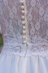 Lifestyle, detail of the seam texture of the bride's beautiful white dress. Caucasian brunette on her wedding day