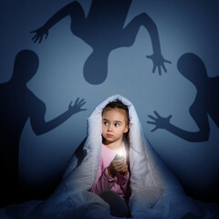 girl under the covers with a flashlight