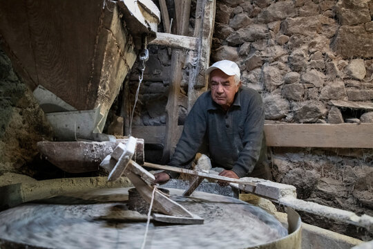 Old mill for grinding grain up close. The miller grinds grain