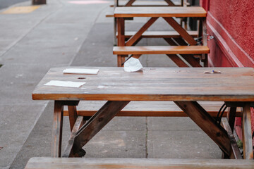 Discarded face mask on a picnic table outside of a restaurant. Forgotten protection against coronavirus and covid-19.