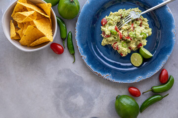 Fresh Guacamole with Ingredients and Tortilla Chips. Traditional Mexican Food. Top View.
