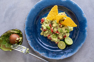 Fresh Guacamole with Tortilla Chips and Empty Avocado Shell. Traditional Mexican Food. Top View. Copy Space.
