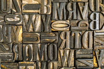 Old wooden letterpress used in a printing press to create reliefs by impressing them against sheets of paper after covering them with ink. Jumbled antique letters. Alphabet background.