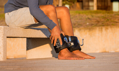 Man putting on anti gravity or inversion boots for upside down hanging. Sports equipment. 