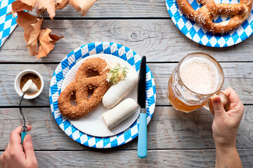 Celebrating Oktoberfest alone. Traditional food and beer, weisswurst sausage and pretzels.