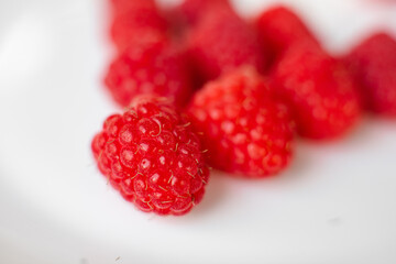 A picture of a few fresh pink raspberries lies on a white background. Background and picture for...