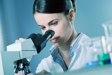 Female researcher using microscope